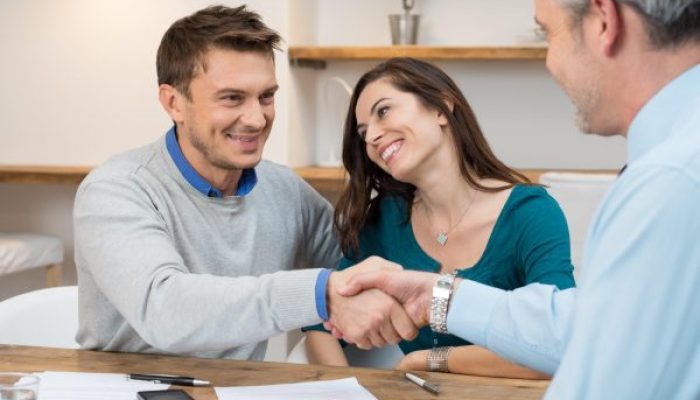 Kim jest windykator Happy young couple shaking hands for a financial agreement