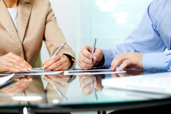 Business people sitting together and making notes at workplace